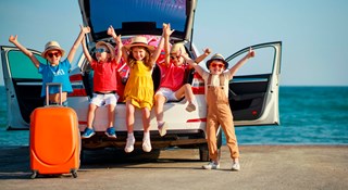Kinderen op vakantie bij auto